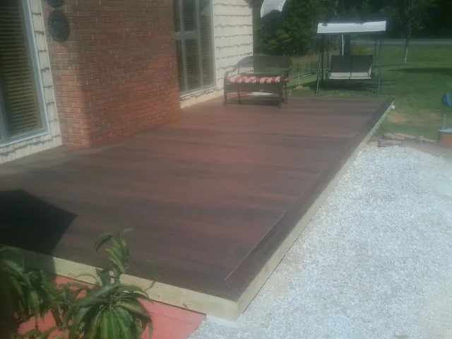 Freshly stained wood deck built against a brick home in Summersville