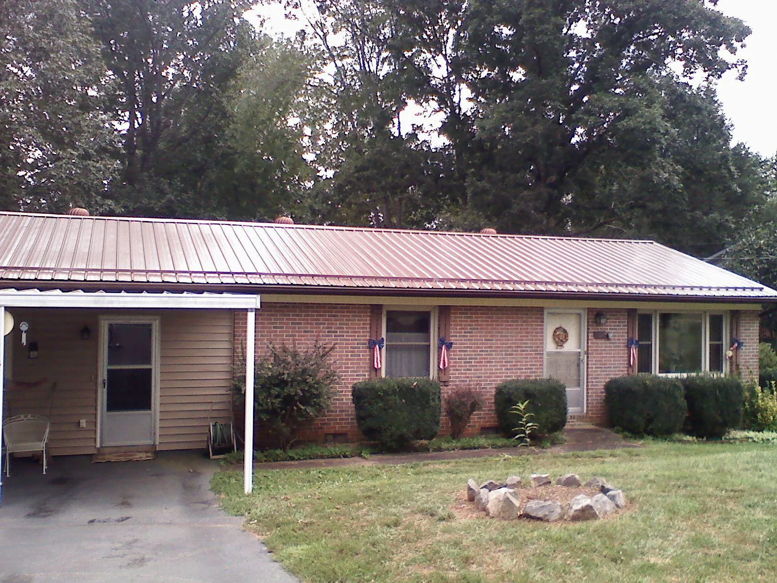 Bronze metal roof and carport on a brick ranch home — Roof Repair work by our crew in Summersville
